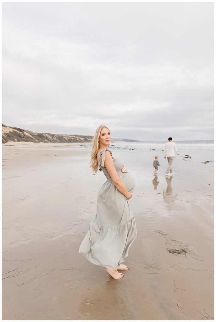 Family of three on the beach in Crystal Cove during their First Year Baby Membership with Halleigh Hill. Newport Beach Photographer
