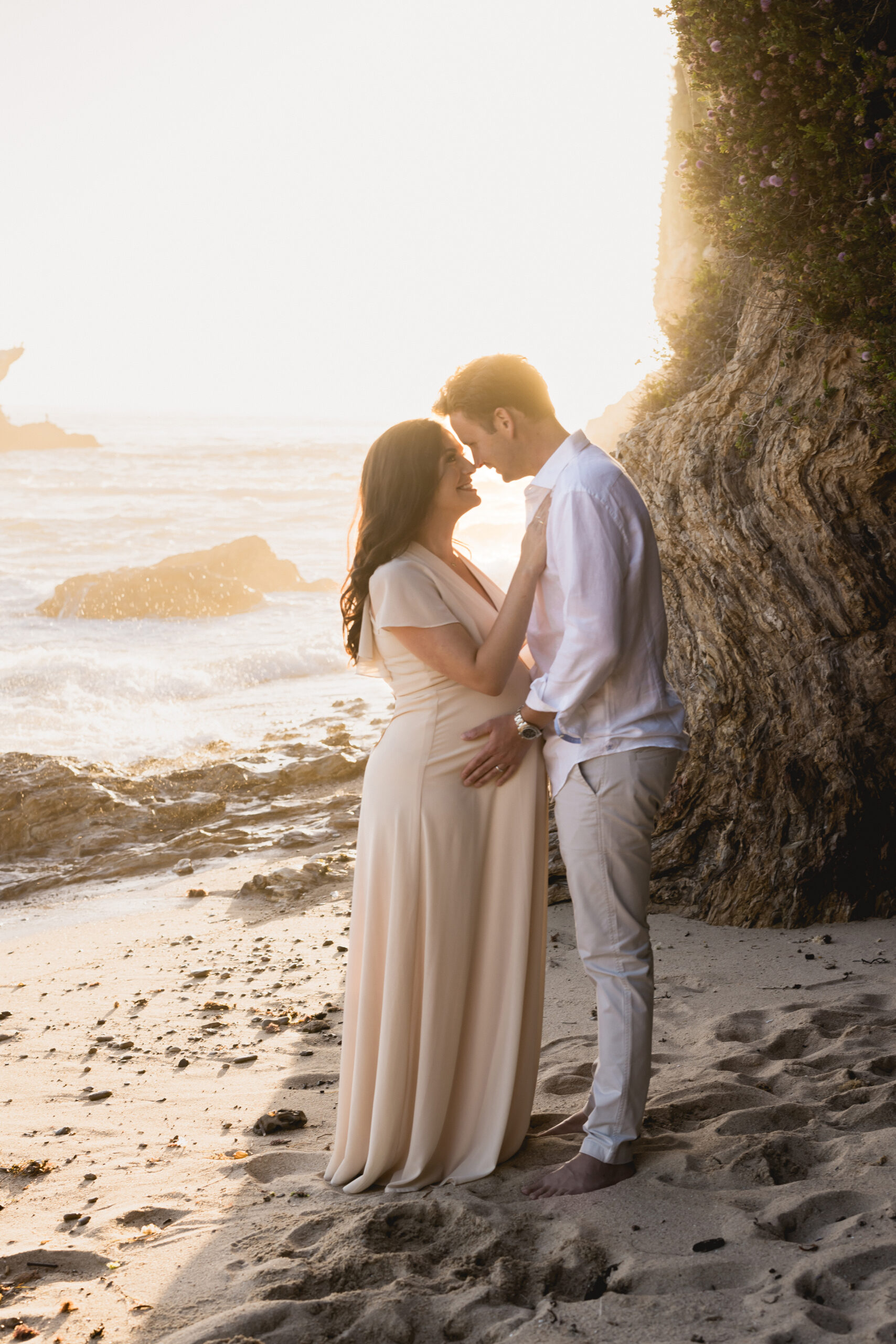 Mom and dad to be on a beach in Corona Del Mar | Image by Halleigh Hill